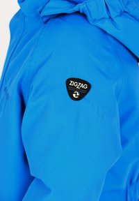 Blauwe waterdichte jas met een logo-opdruk op de schouder, met een gladde, matte textuur en een verstelbare capuchon.