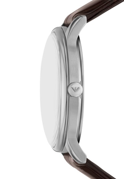 Silberner Edelstahl-Uhrengehäuse mit einem glatten, runden Profil; braunes Lederarmband, das an eleganten Bandanstößen befestigt ist; dezentes Logo auf der Krone.