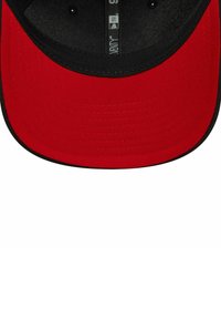 Casquette de baseball rouge avec une visière noire, présentant un intérieur texturé et une visière légèrement courbée. Le dessous est également noir.