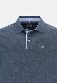 Navyblå polo shirt med texturerad tyg, knappad krage, ljusblå detaljer och en liten logotyp på bröstfickan.