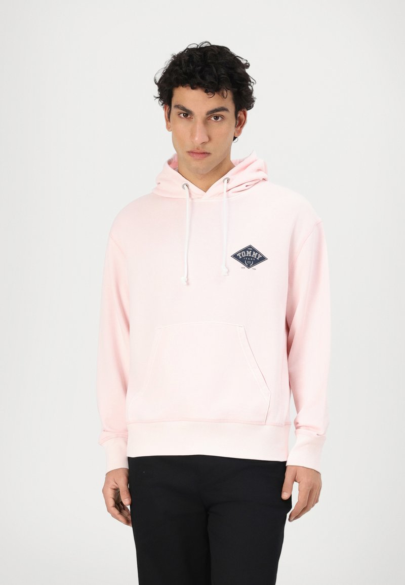Helle rosa Kapuzenpullover aus Baumwollmischung, mit einer Fronttasche und verstellbarem Kordelzug an der Kapuze. Marineblaues Logo-Patch auf der linken Brust. Lange Ärmel.