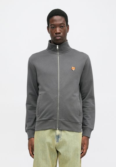Gray zip-up sweatshirt made of smooth fabric, featuring a high collar, two front pockets, and an orange fox head logo on the chest.