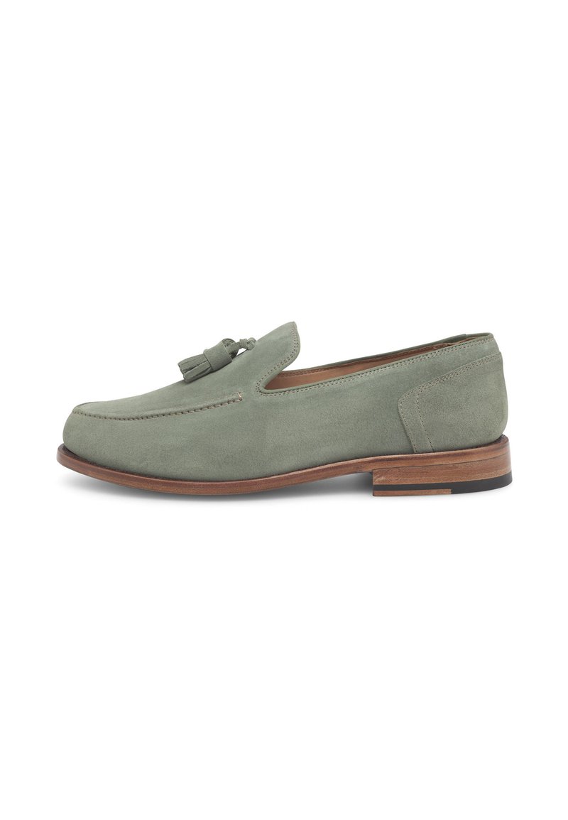 Groene suède loafers met een ronde neus, decoratieve kwastdetails en een lage houten hak. Gladde textuur met contrasterende stiksels.