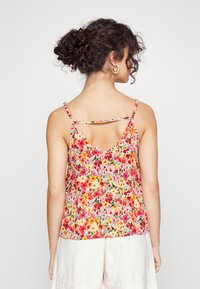 Camisola floral em tecido leve, apresentando um padrão multicolorido de flores vermelhas, rosas e amarelas, com alças finas e um design de costas em decote redondo.