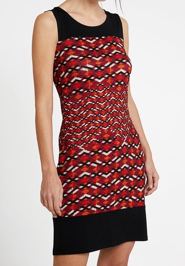 Robe sans manches à motifs rouges et noirs, présentant un design géométrique avec un corsage ajusté et une jupe noire unie. Tissu texturé.