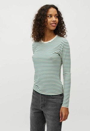 Top a maniche lunghe, aderente, con righe orizzontali verdi e bianche, scollatura rotonda e tessuto in cotone morbido. Abbinato a jeans grigi scuri.