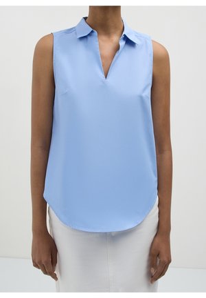 Blouse sans manches bleu clair avec col et encolure en V portée par une personne portant un pantalon clair sur un fond uni.