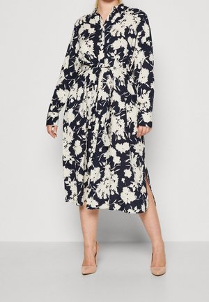 Marineblå og kremfarvet blomsterkjole, lange ærmer, bælte i taljen, knælængde med sideslidser, lavet af letvægtsstof.