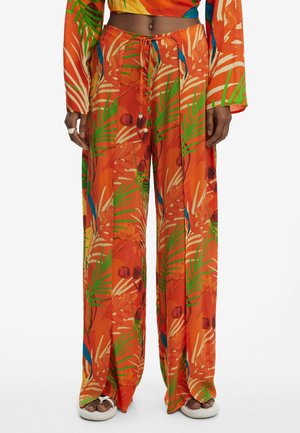 Pantaloni largi portocalii cu un imprimeu floral tropical, care prezintă frunze verzi și accente roșii. Realizați dintr-un material ușor, fluid.