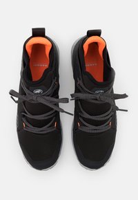 Scarpe atletiche nere con accenti arancioni all'interno, tessuto testurizzato e suola in gomma grigia. Presentano lacci grigi e dettaglio del logo sul lato.