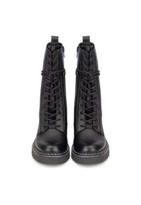 Botas de tobillo de cuero negro con un diseño de cordones, cremalleras laterales y costuras blancas en la suela gruesa. Textura suave con un acabado elegante.
