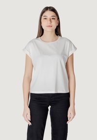 T-shirt bianco a maniche corte con orli arrotolati, scollatura rotonda e un design del logo discreto sul davanti. Abbinato a pantaloni neri.