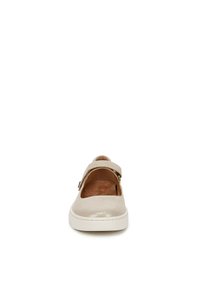 Chaussure slip-on en daim beige avec un design à découpes, une sangle ajustable et une semelle en caoutchouc blanche. Texture lisse avec des détails en matériel minimal.