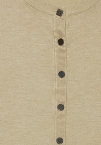 Beige pletený henley s kulatým výstřihem, který má pět černých knoflíků vpředu a texturované žebrované detaily.