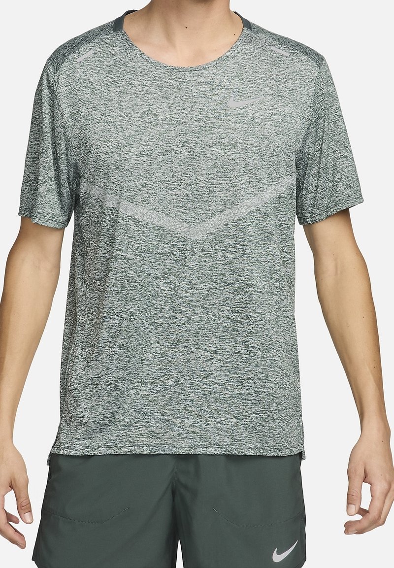 Camiseta deportiva de manga corta de Nike en tejido verde jaspeado. Presenta un escote redondo, un sutil patrón de chevron y acentos reflectantes.