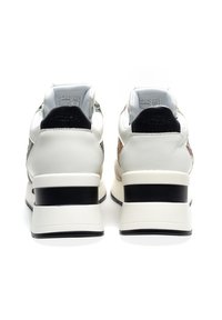 Sneaker bianche con pannelli testurizzati, accenti neri e un tacco spesso nero. Collo e linguetta imbottiti con logo sul tacco.