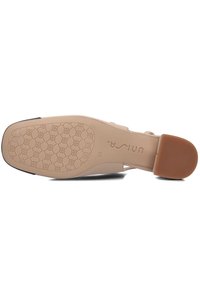 Beige schoenzool met een gegroefde rubberen oppervlakte met een geometrisch patroon. Stevige hak en ingekraste merknaam zichtbaar.