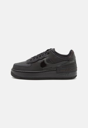Niskie czarne sneakersy Nike Air Force 1 z skórzaną cholewką, błyszczącym czarnym logo Swoosh, podwyższoną podeszwą i oznaczeniem "AIR" na pięcie.