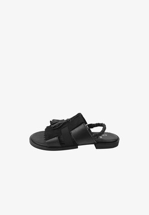 Sort åben-tå flad sandal med elastisk bagrem, læderoverdel og dekorative frynsetaske på toppen, vist fra siden.