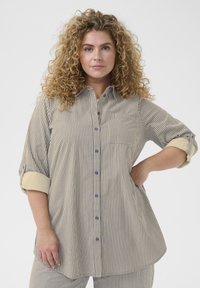 Blouse rayée avec un devant à boutons, un col, des manches retroussées avec des poignets contrastés, et une coupe loose.