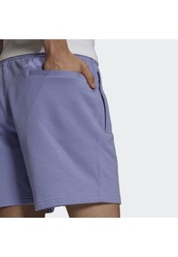 Světle fialové šortky vyrobené z měkkého materiálu, s elastickým pasem a bočními kapsami. Design je jednoduchý s rovnými nohavicemi.