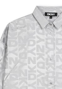 Chemise DKNY en tissu argent clair présentant un motif de logo répétitif, une fermeture à boutons et un col classique avec une texture synthétique lisse.