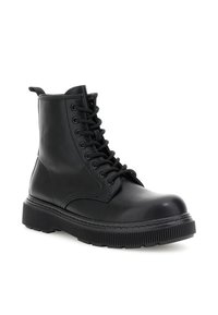 Stivale da combattimento in pelle nera con suola spessa e scanalata, chiusura con lacci davanti, design alto alla caviglia e linguetta sul retro.
