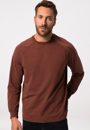 Langsleeve crew neck shirt in roestkleurige stof. Kenmerkt raglanmouwen en een ontspannen pasvorm met ribgebreide manchetten en zoom.