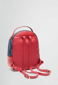 Zaino in pelle rossa con un pannello in tessuto blu navy che presenta un piccolo motivo a logo. Spallacci regolabili e dettagli in acciaio dorato.