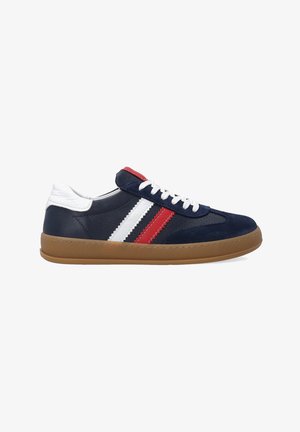 Baskets bleu marine avec des rayures blanches, rouges et grises, tige en daim, languette de talon blanche et semelle en caoutchouc marron. Présente un laçage sur le devant.