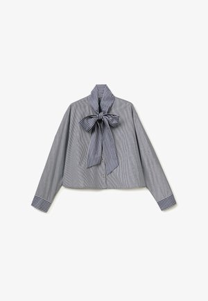 Blouse grise à manches longues avec des rayures blanches verticales, avec un grand col à nœud papillon et des poignets rayés assortis.