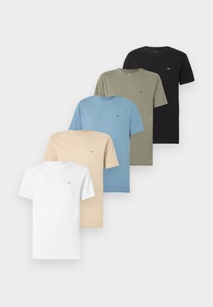 Cinq t-shirts unis à manches courtes et col rond, en blanc, beige, bleu, vert olive et noir, présentés en chevauchement sur un fond clair.