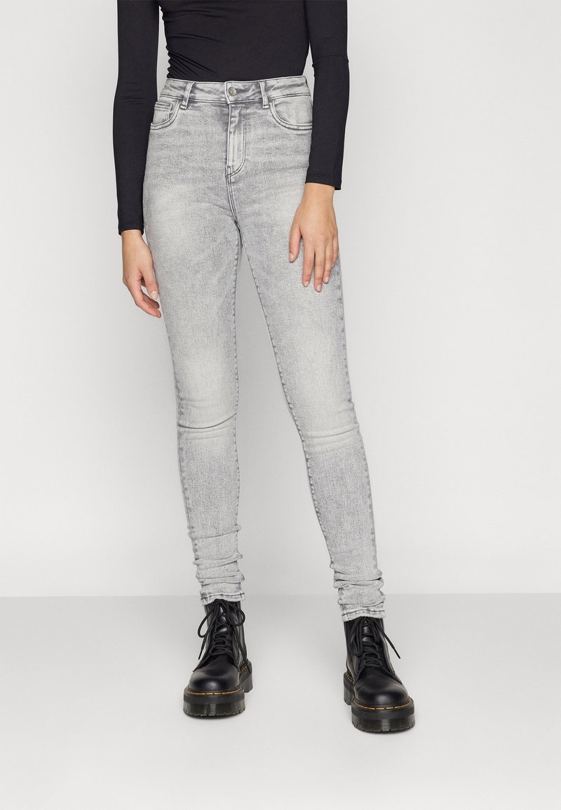 Höga grå skinny jeans med en blekt finish och subtila slitage. Kombineras med svarta snörstövlar med en kraftig sula.