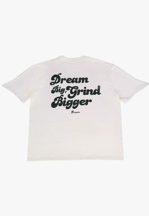 T-shirt en coton blanc avec un texte noir au dos, indiquant "Rêve grand, travaille plus dur." Coupe ample avec des manches courtes et un col rond.