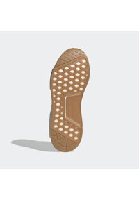 Pohja urheilusneakerissa, jossa on kuvioitu ruskea kumi pintas, jossa on kuusikulmaisia kuvioita ja kerma-valkoinen välipohja. Selkeä brändäys on näkyvissä.