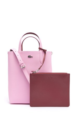 Bolso de cuero rosa con asas superiores y correa ajustable, mostrado con un estuche de cuero marrón con cremallera desmontable en la parte delantera.