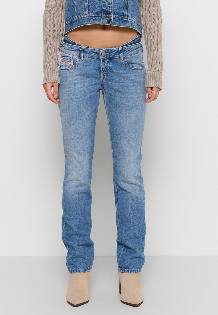 Jeans in denim azzurro chiaro con gamba dritta, caratterizzati da un design a cinque tasche e una leggera scoloritura. Indossati con un maglione corto e tacchi beige.
