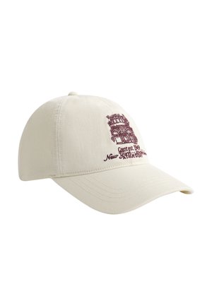 Off-white baseballpet met bordeauxrode geborduurde vintage gebouw en tekst met de woorden "Gant est. 1949 New York Brooklyn A True Story" op de voorkant.