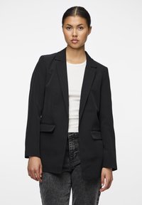 Černý blazer s přiléhavým střihem, jedním knoflíkem, dvěma předními kapsami a hladkou texturou. Nositý přes bílou ribbenou košili.