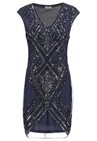 Marinblå klänning med djup V-ringning och korta ärmar, dekorerad med ett geometriskt mönster av silverpaljetter. Transparent tyg framhäver designen.