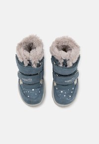 Blaue Kinderstiefel mit weichem grauem Kunstfellfutter, zwei Klettverschlüssen und weißen Punkten auf dem Obermaterial.