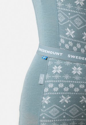 Lichtblauw thermoshirt met een sneeuwvlokpatroon in het wit, horizontale banden en een logo-band met een accent van de Zweedse vlag.