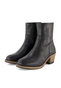Botas de cuero negro hasta el tobillo con un acabado ligeramente texturizado, puntera redondeada y tacón de madera apilado. Costuras laterales y detalle del logotipo visibles.