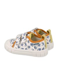 Zapatillas de lona blancas con patrones de dibujos animados, que presentan acentos en naranja y amarillo, cintas de velcro y suelas de goma texturizadas.