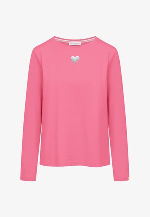 Różowa koszula z długim rękawem z srebrnym sercem umieszczonym na środku poniżej dekoltu, okrągły dekolt i prosty prosty dół.