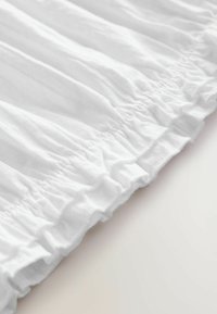 White textured fabric with gathered ruffles along the edge, creating a soft, wavy appearance. Smooth texture with a crisp finish.