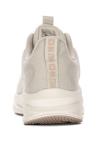 Jasno beżowy but sportowy z teksturowaną górą z siateczki, wyraźnym uchwytem na pięcie i mlecznobiałą podeszwą. Posiada subtelną markę na pięcie.