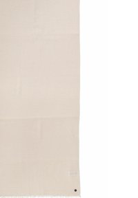 Tissu beige clair avec des bords en franges, texture lisse, forme rectangulaire et un petit détail de bouton sombre près du coin inférieur droit.