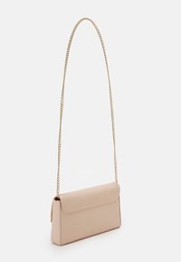 Sac à main en cuir beige de forme rectangulaire, avec une fermeture à rabat et une longue bandoulière en chaîne dorée. Texture lisse avec des lignes épurées.