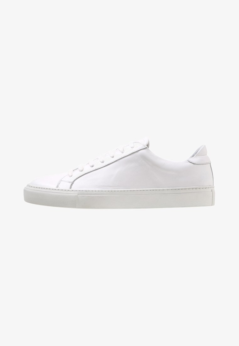 Baskets en cuir blanc profil bas avec semelle en caoutchouc blanche et lacets blancs, vues de côté extérieur sur un fond uni.